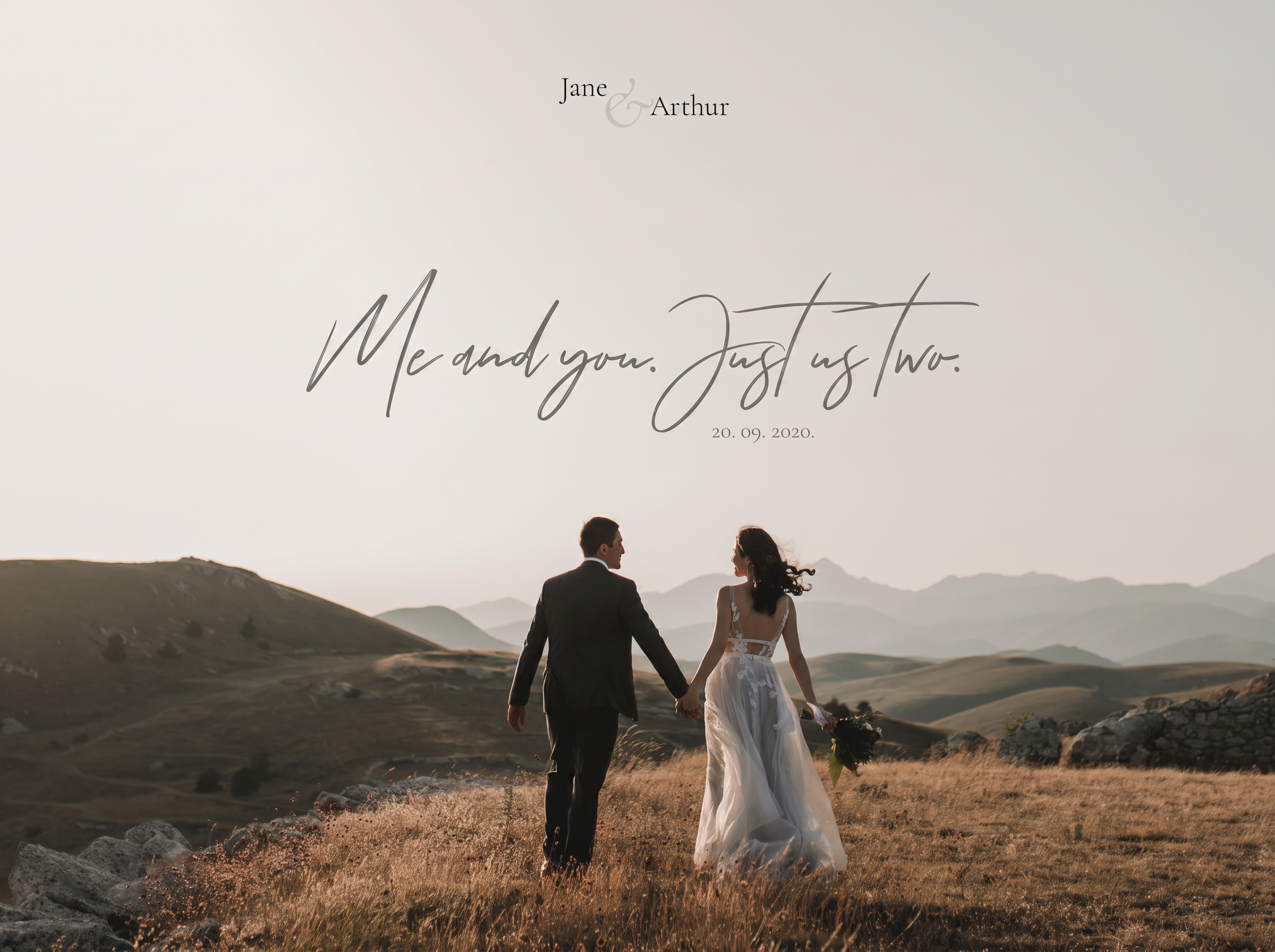 Couple walking hand in hand through mountain meadow at golden hour